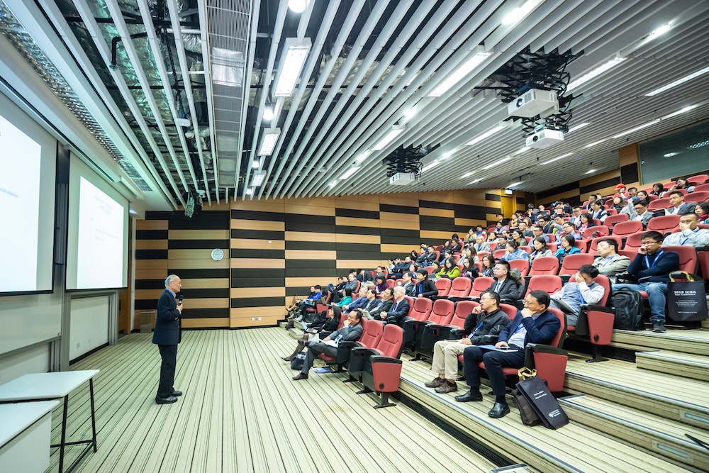 Ergonomics consultant delivering training to a large group of professional business people, inside a Sydney lecture theatre.